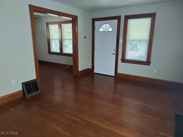 Entryway with dark wood-style floors and baseboards