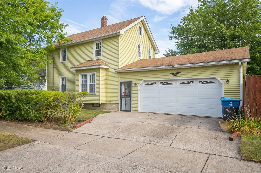 Side of Main house featuring an attached garage and driveway