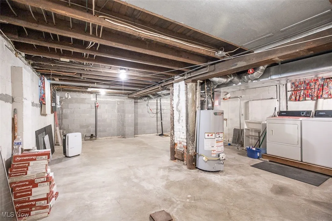 Unfinished below grade area with water heater and washer and dryer Main house
