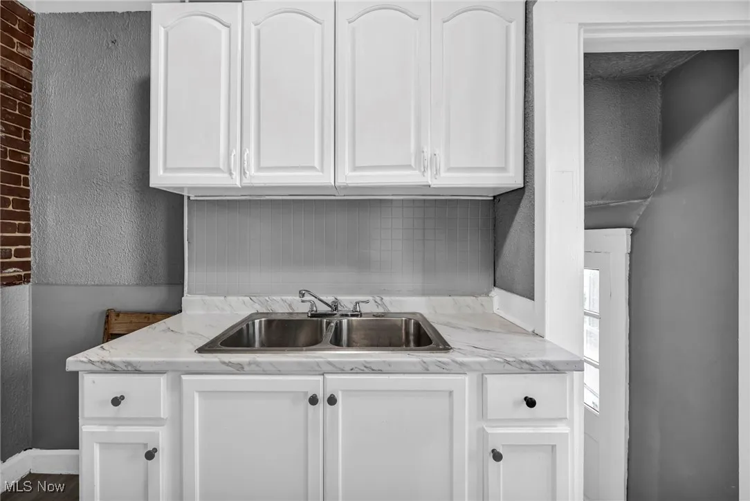 Laundry area with a textured wall and a sink