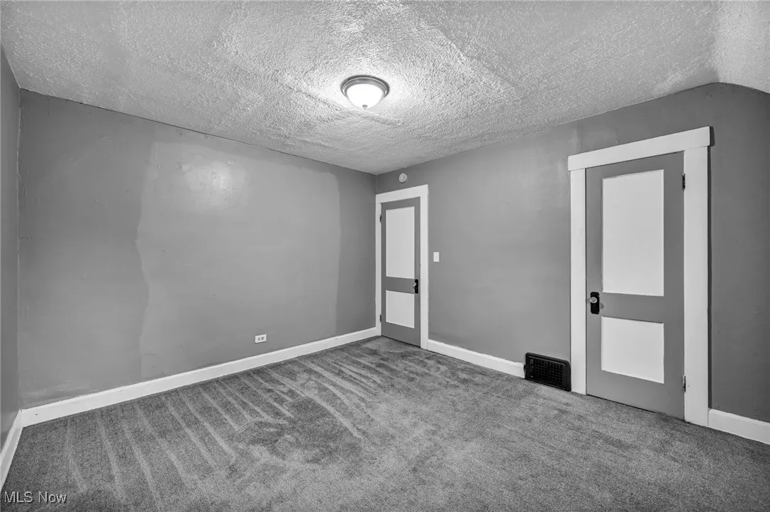 Spare room featuring a textured ceiling and carpet