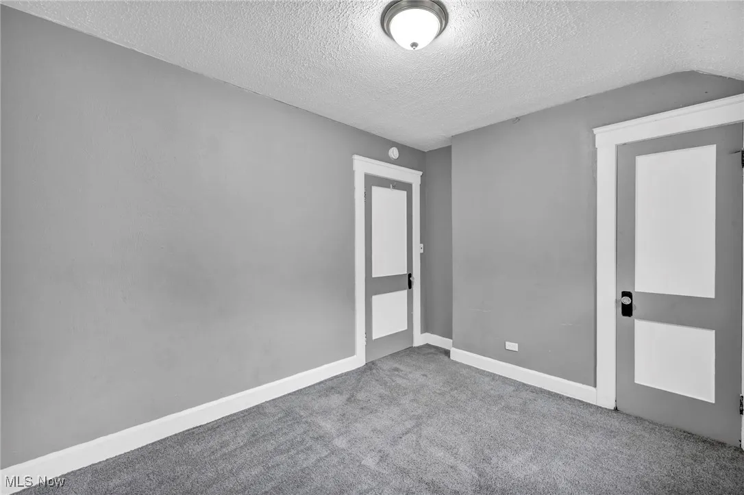 Unfurnished bedroom featuring a textured ceiling and carpet floors