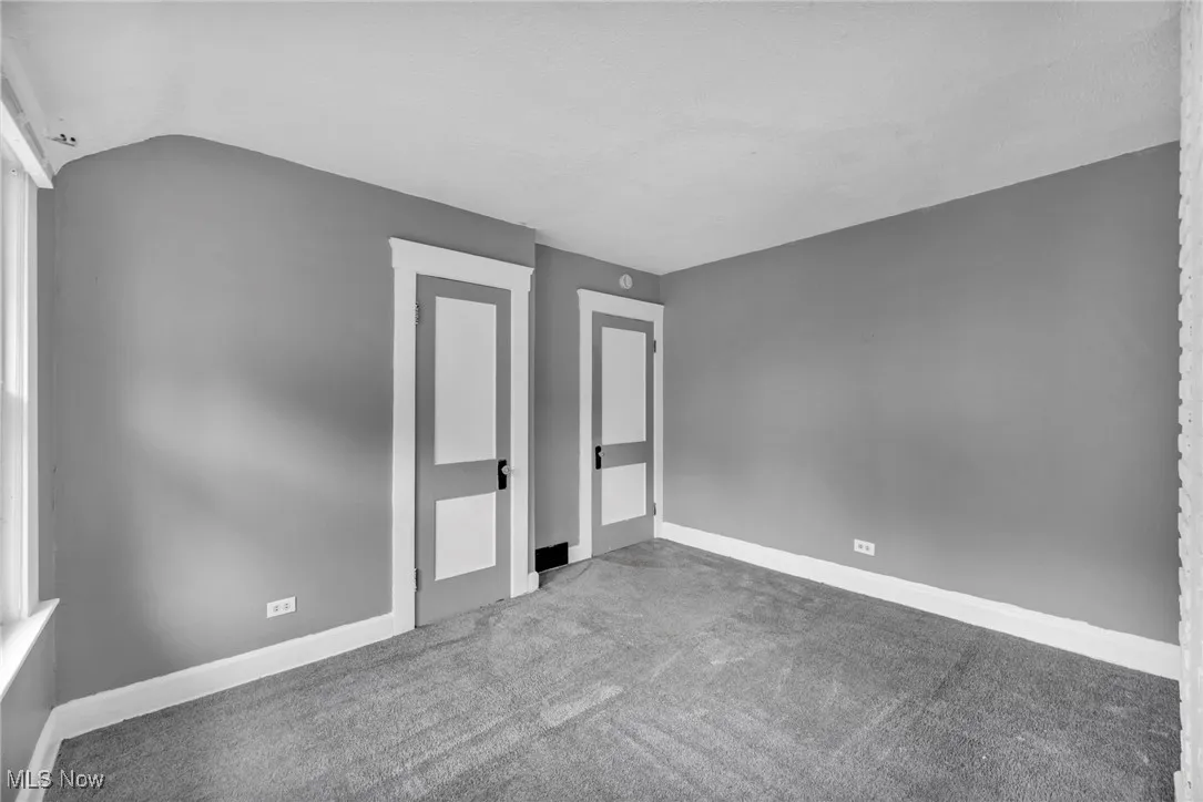 Unfurnished bedroom with carpet and vaulted ceiling