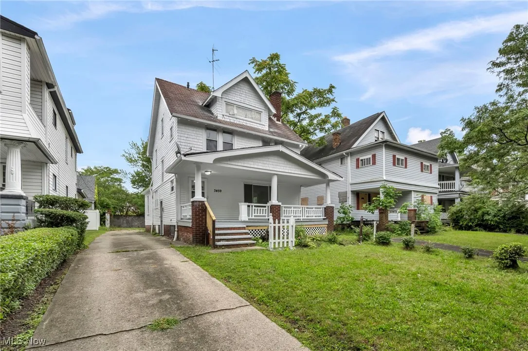 Traditional style home featuring a porch, a chimney, and driveway