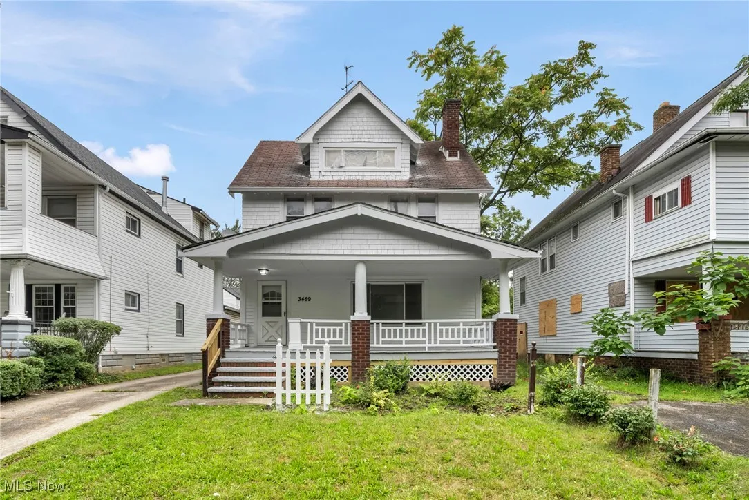 Traditional style home featuring covered porch and a front lawn