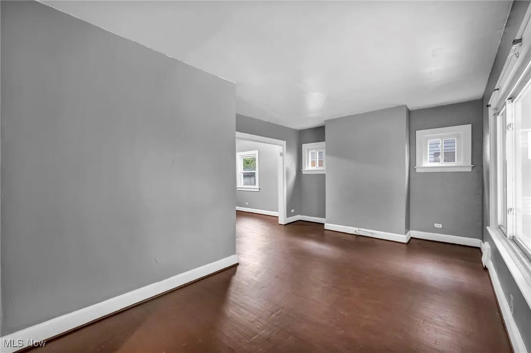 Empty room with dark wood finished floors and plenty of natural light