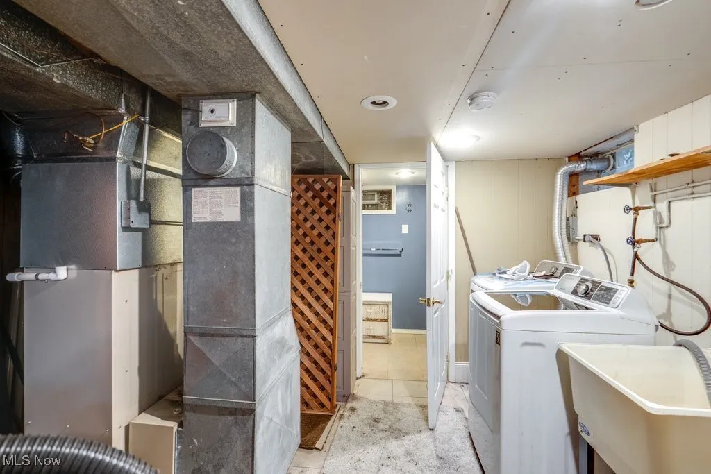 Laundry room featuring heating unit and separate washer and dryer