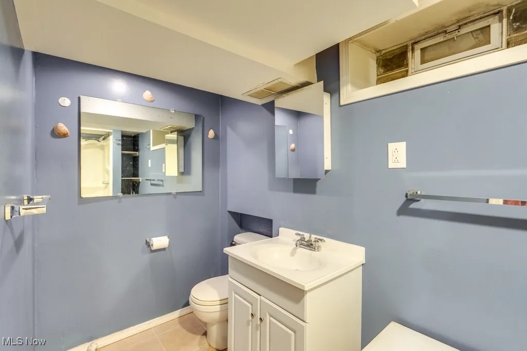 Half bathroom with vanity and tile patterned floors