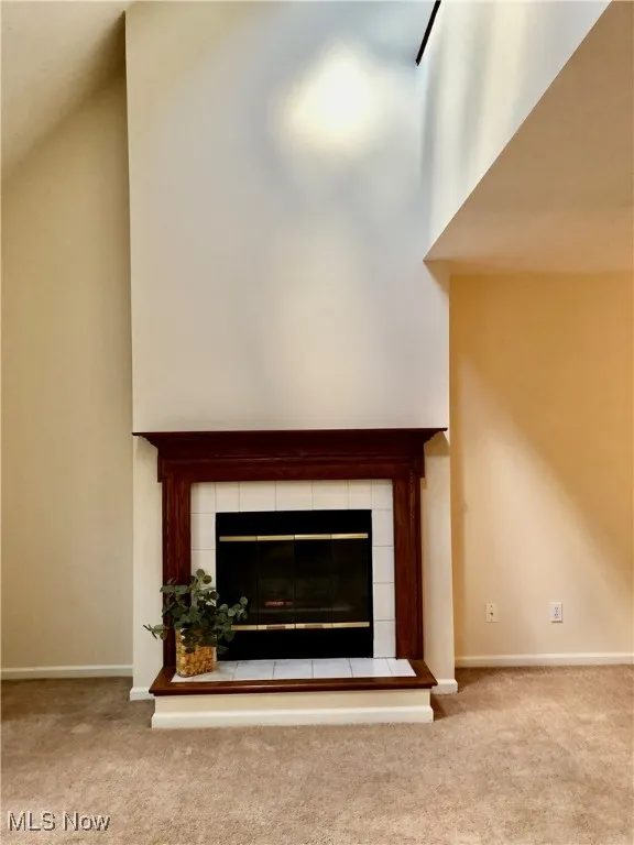 Detailed view of a tile fireplace and carpet