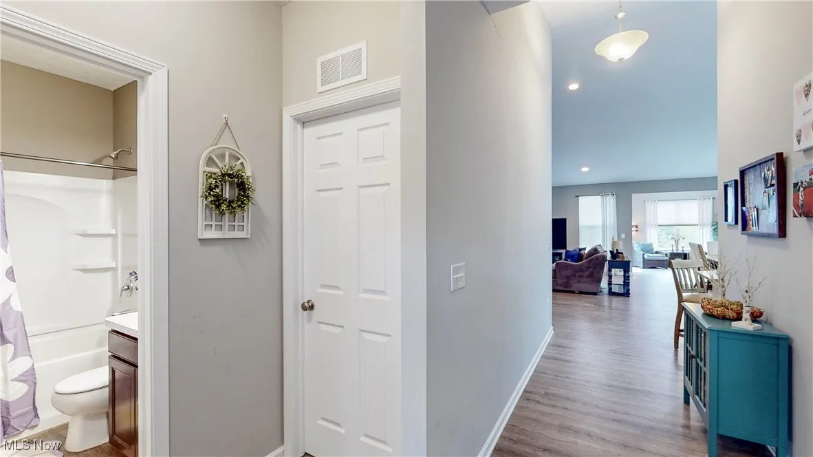 Hallway with light wood-style flooring and recessed lighting