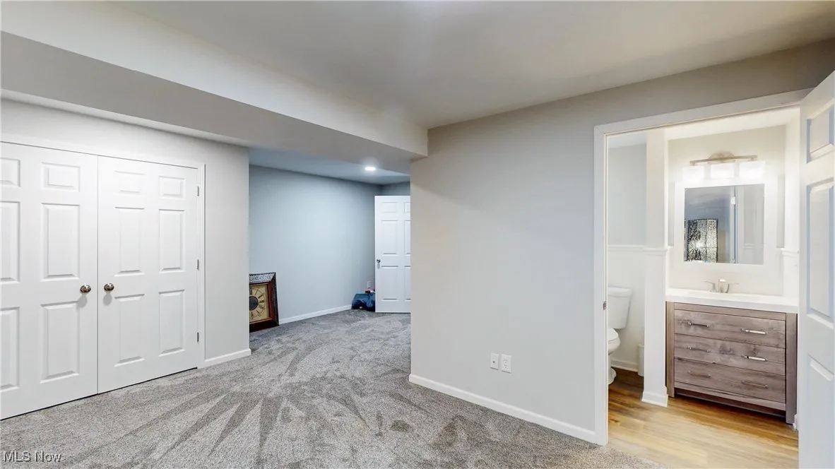  bedroom featuring a closet, ensuite bathroom, and light colored carpet