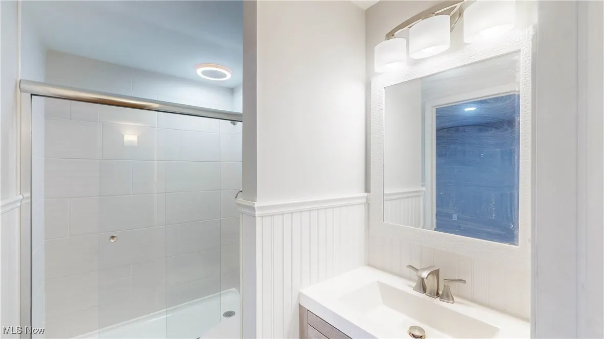 Full bathroom featuring vanity and a shower stall