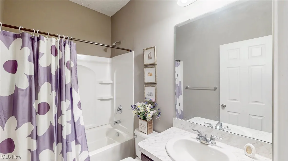 Full bath featuring shower / tub combo and vanity