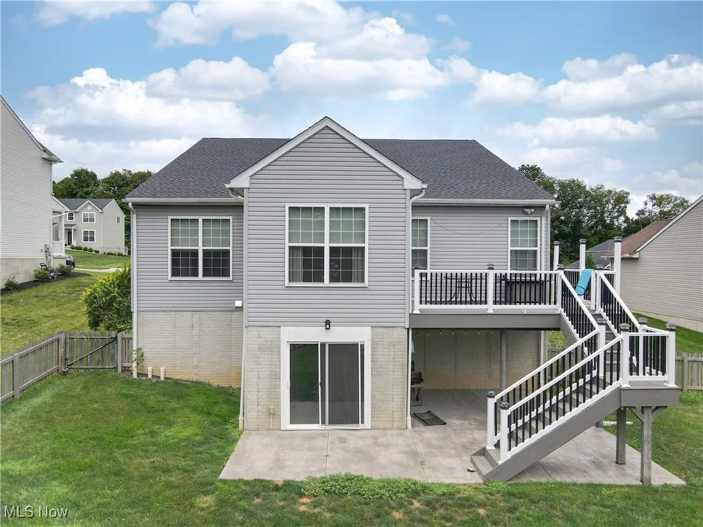 Back of property with a patio area, a shingled roof, and stairway