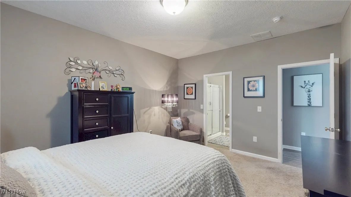 Bedroom with light carpet and a textured ceiling