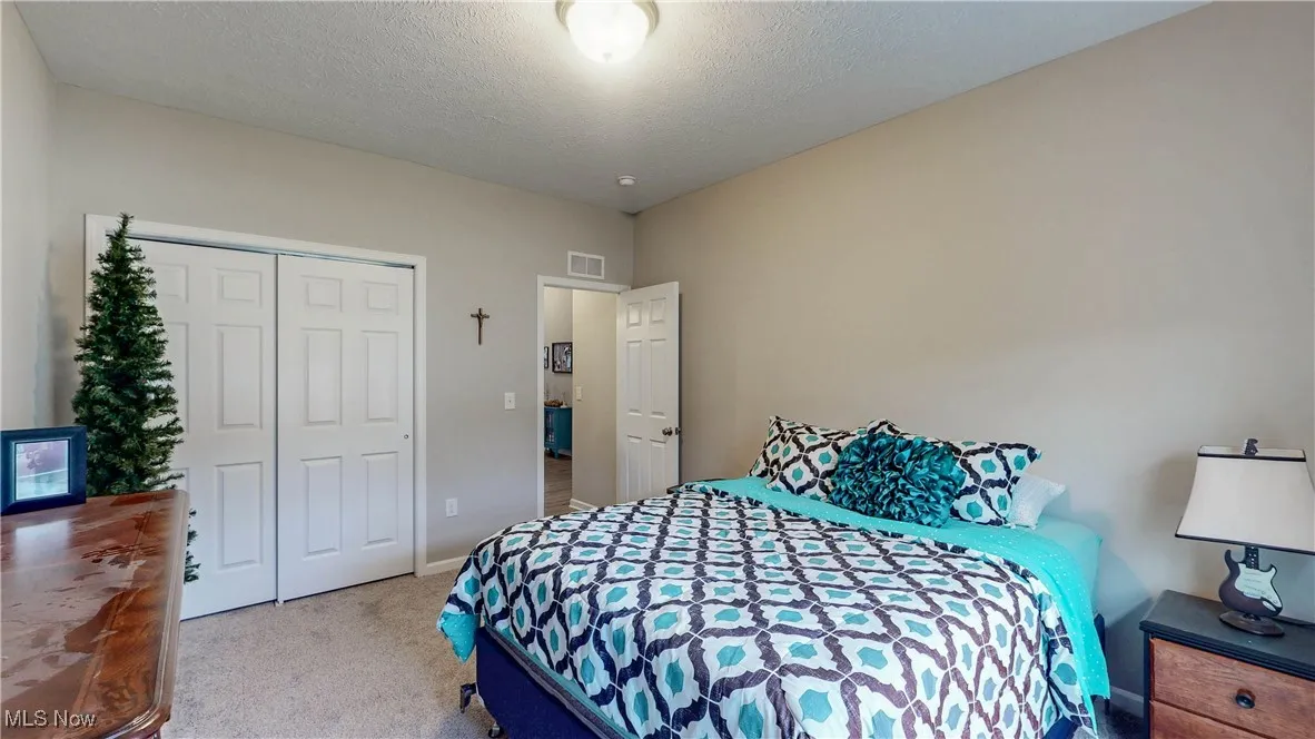 Carpeted bedroom featuring a closet and a textured ceiling