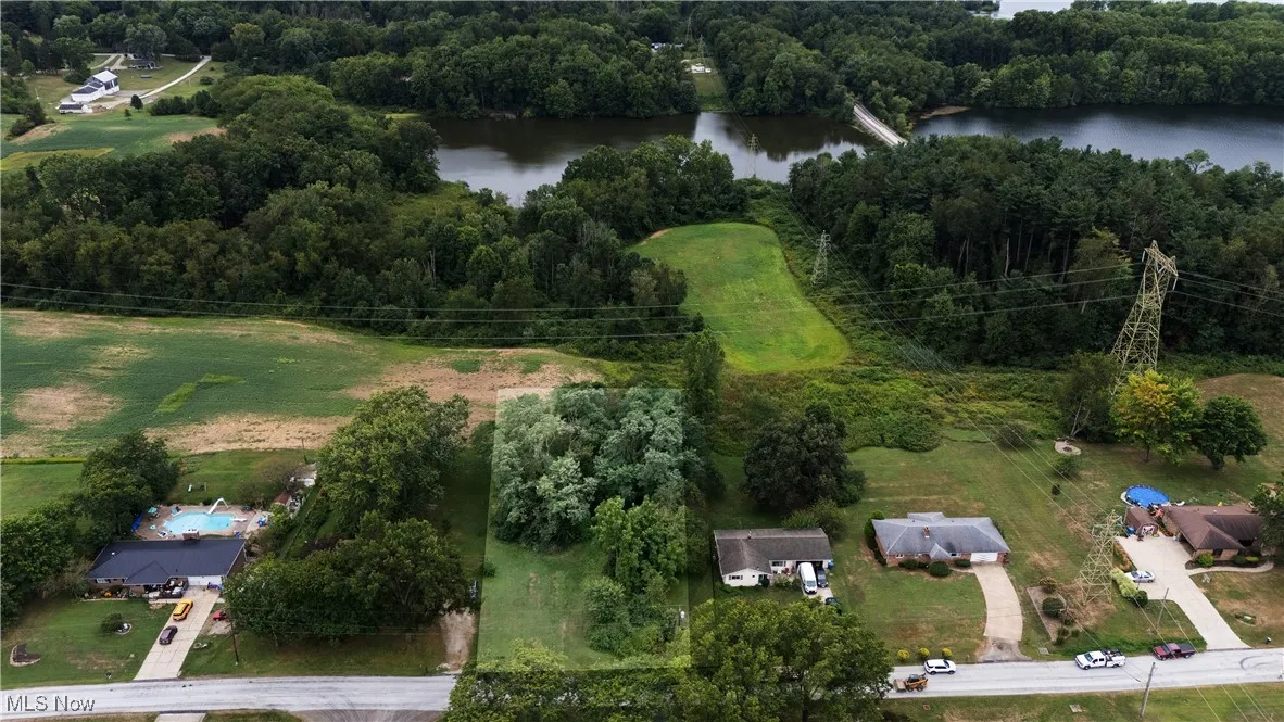 View of property location featuring a nearby body of water and a heavily wooded area
