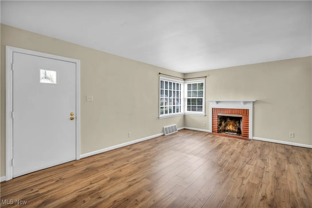 Unfurnished living room featuring wood finished floors and a fireplace