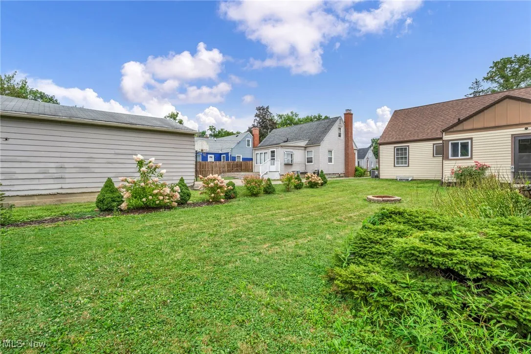 View of yard with an outdoor fire pit and a residential view