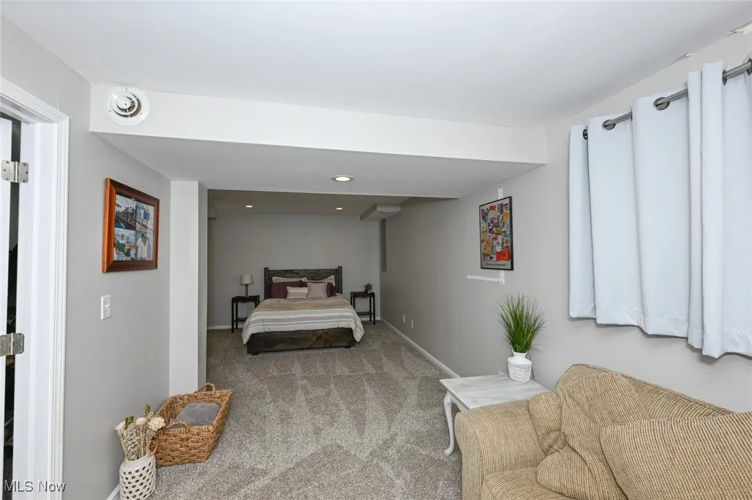 Lower level bedroom with full sized windows, glass sliding doors, and walk in closet