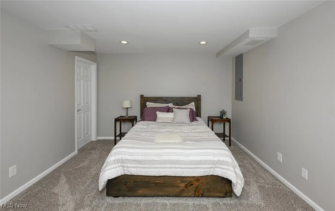 Lower level bedroom with full sized windows, glass sliding doors, and walk in closet