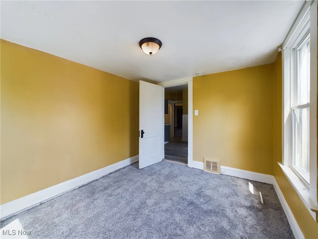 Carpeted spare room with baseboards