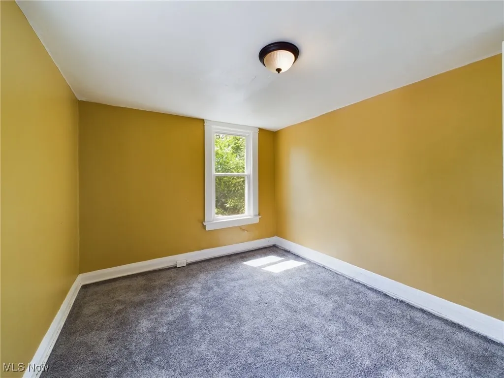 Unfurnished room featuring carpet and baseboards