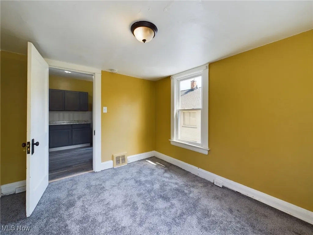 Carpeted empty room with baseboards