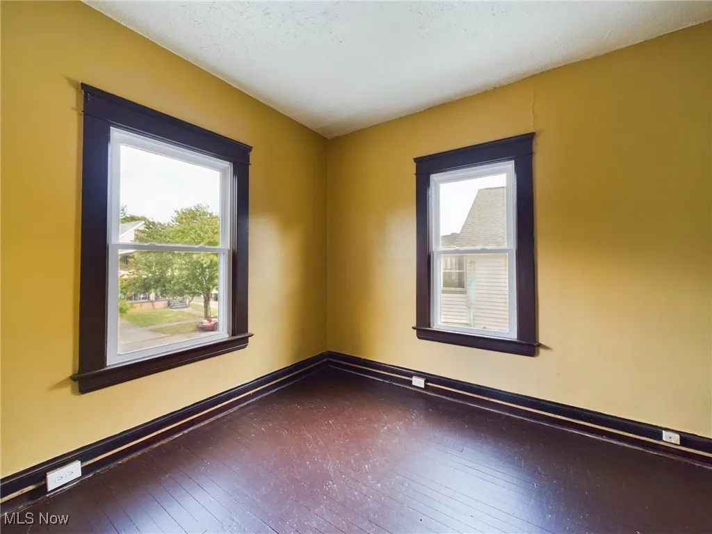 Empty room with baseboards and hardwood / wood-style floors