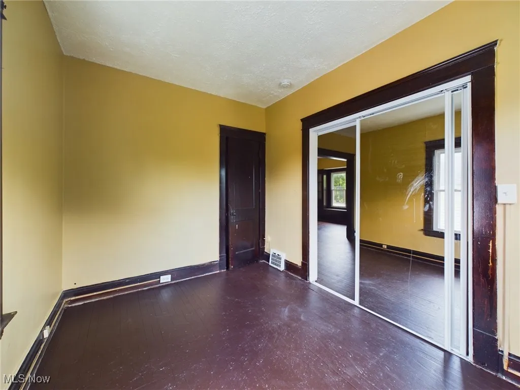 Unfurnished bedroom with a closet, a textured ceiling, and wood-type flooring