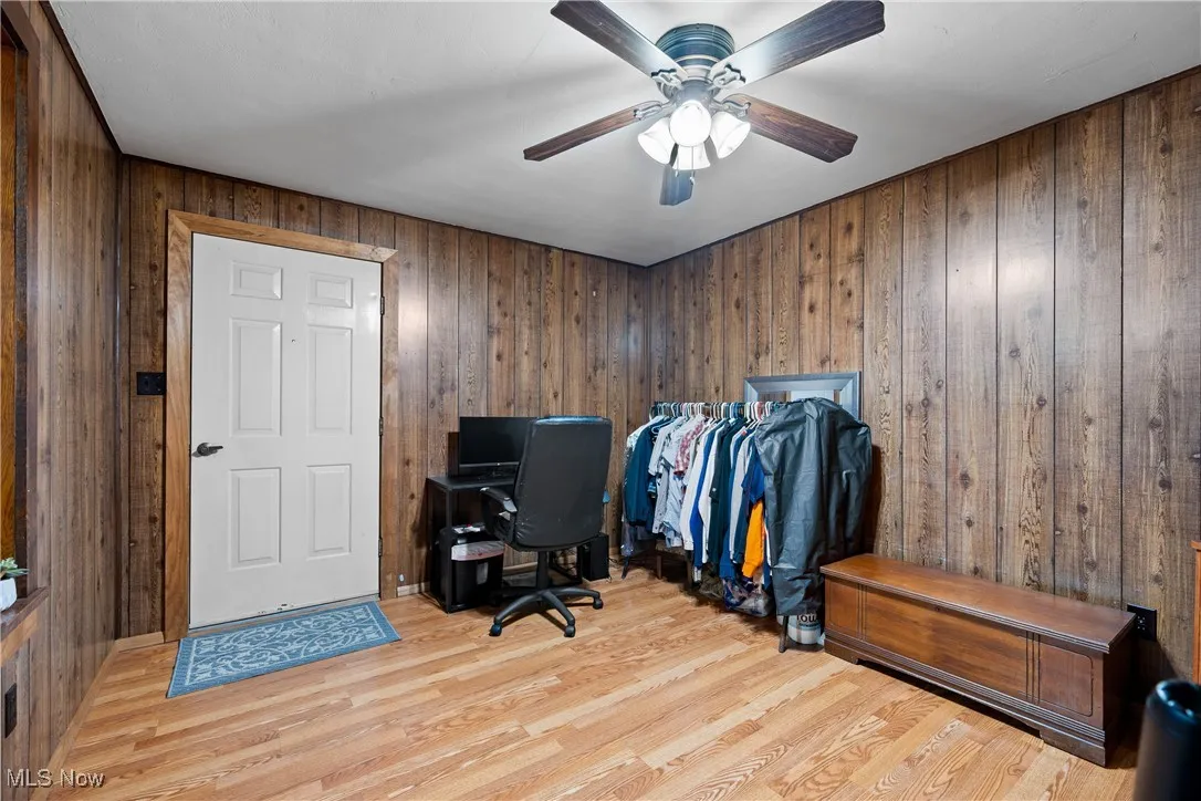 Home office featuring wooden walls and wood finished floors