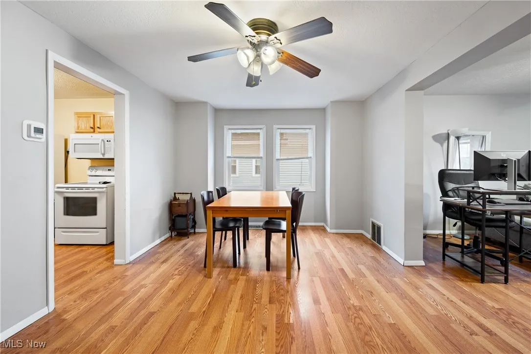 Dining space featuring light wood-type flooring, a ceiling fan, and a desk