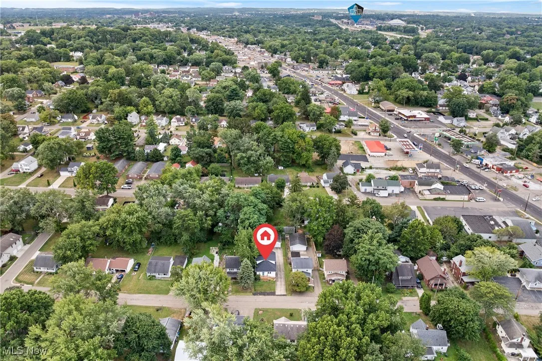 Aerial overview of property's location with nearby suburban area and a tree filled landscape