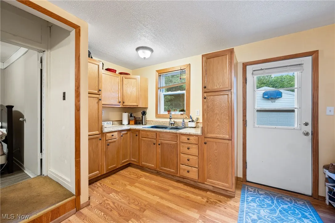 Kitchen featuring a textured ceiling, light countertops, light wood finished floors, and plenty of natural light