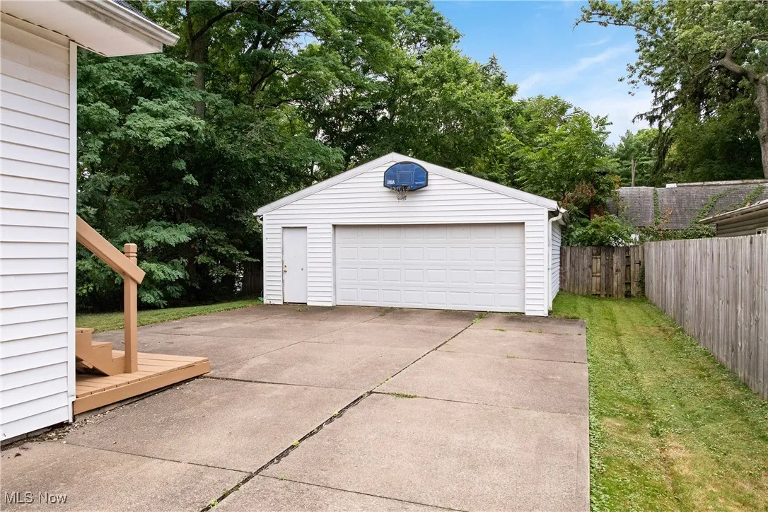 Detached garage featuring view of wooded area