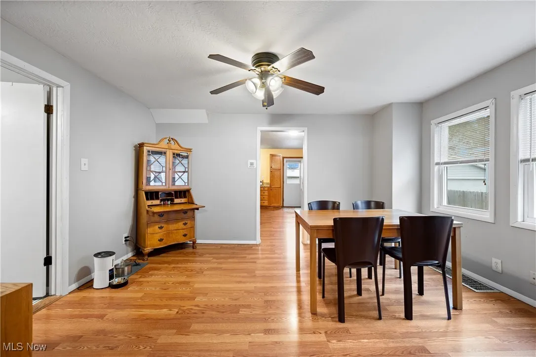 Dining area with light wood finished floors and ceiling fan
