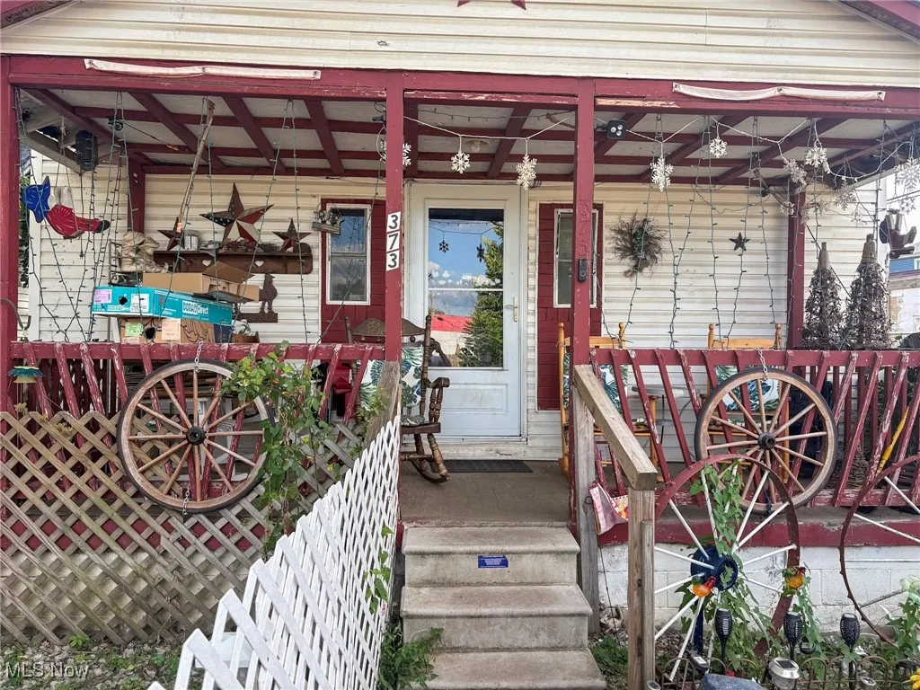 Doorway to property with covered porch
