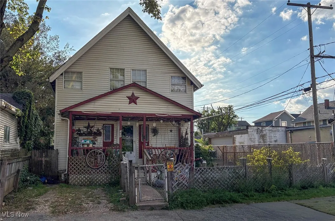 View of front facade with a fenced front yard and a gate