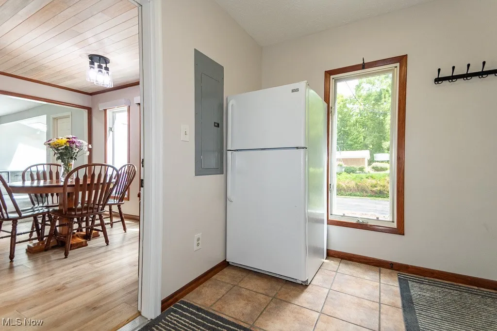 Kitchen with freestanding refrigerator, electric panel, and light wood-type flooring