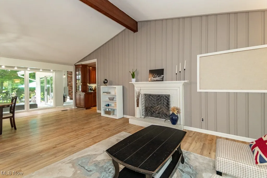 Living area featuring light wood-style flooring and a fireplace with raised hearth