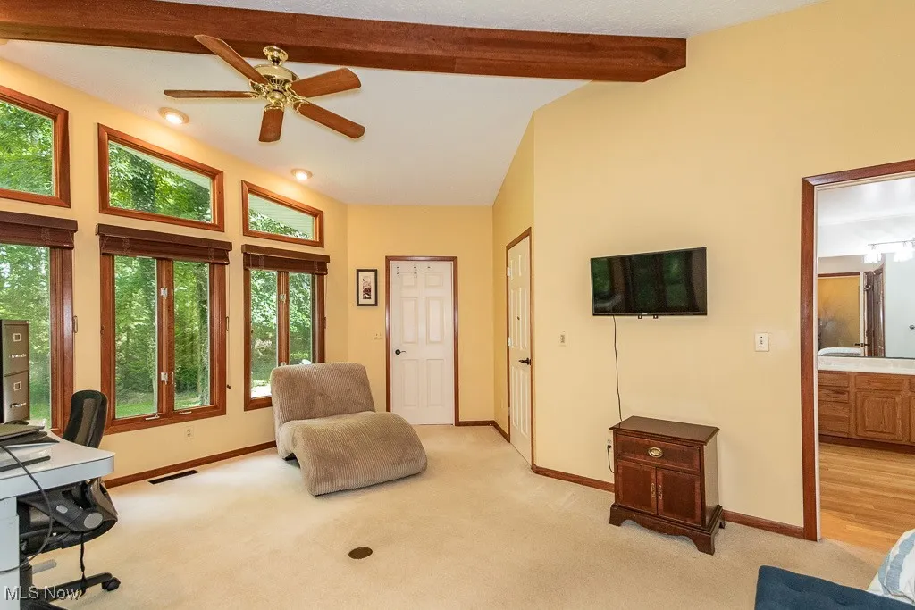 Office with light colored carpet and ceiling fan