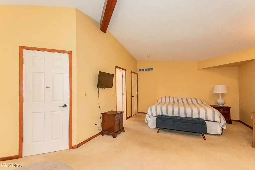Bedroom featuring light carpet and baseboards