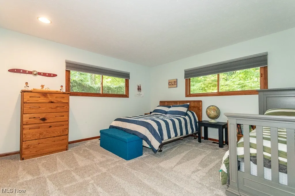 Bedroom with baseboards and light colored carpet