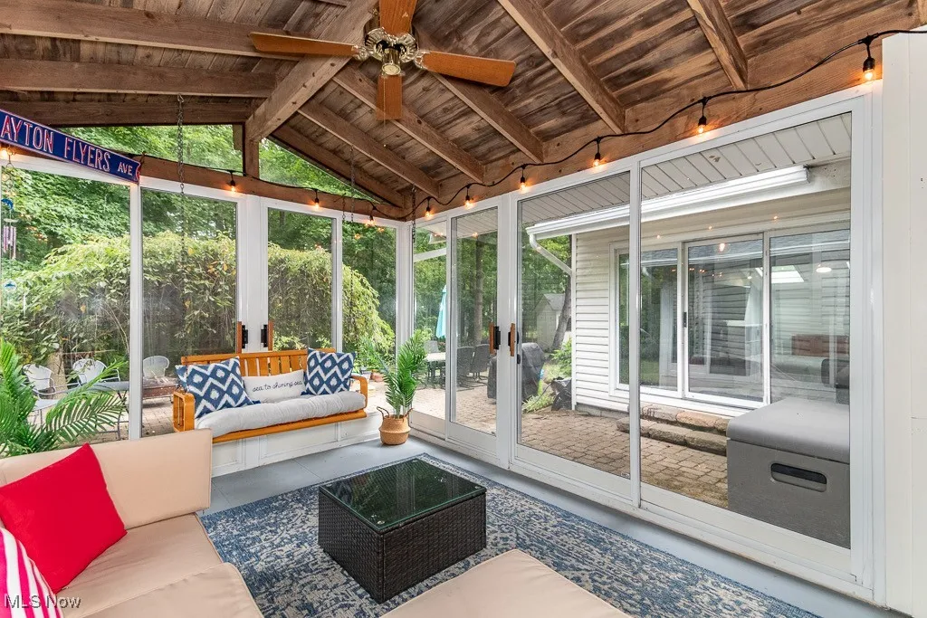 Sunroom featuring an outdoor hangout area, vaulted ceiling, ceiling fan, and french doors