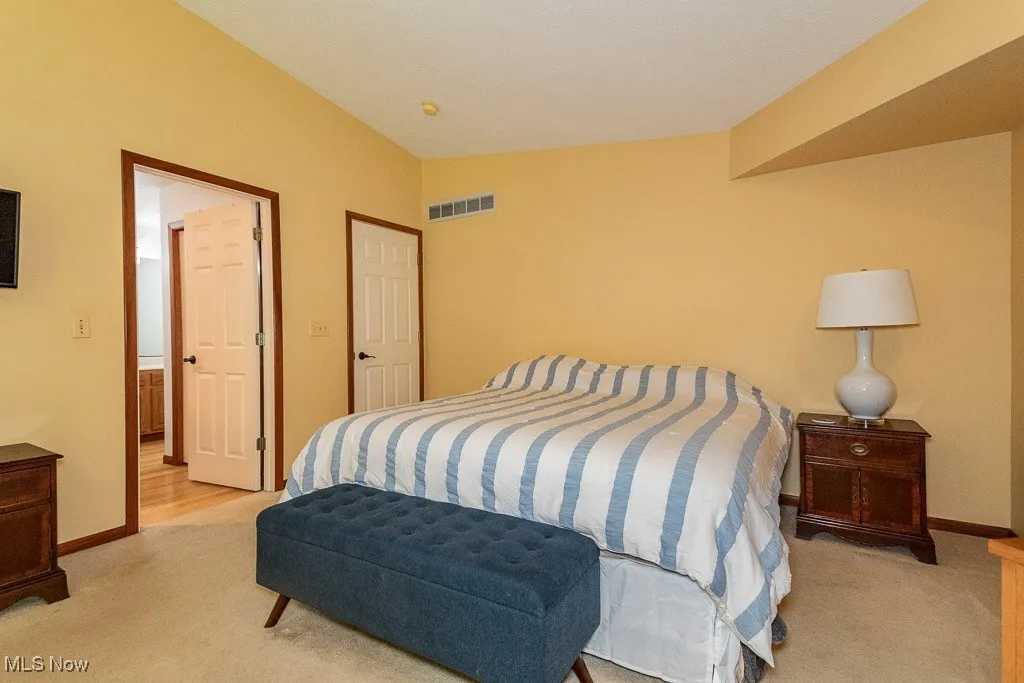 Bedroom featuring vaulted ceiling and light carpet