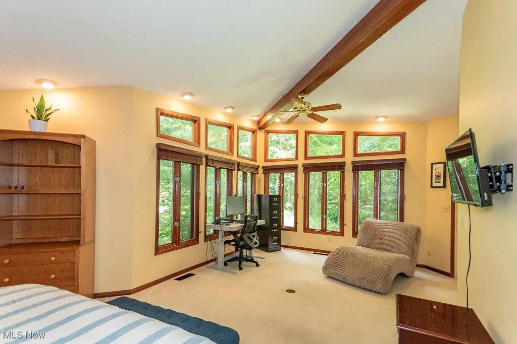 Bedroom featuring beamed ceiling, an office area, and carpet floors