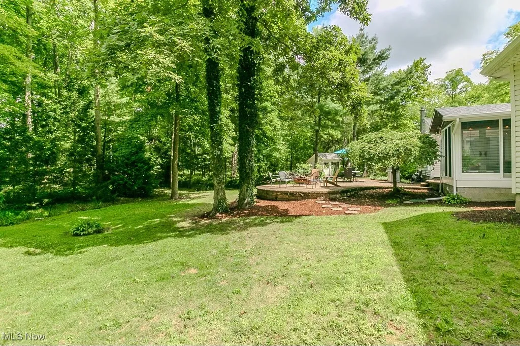 View of grassy yard featuring a patio