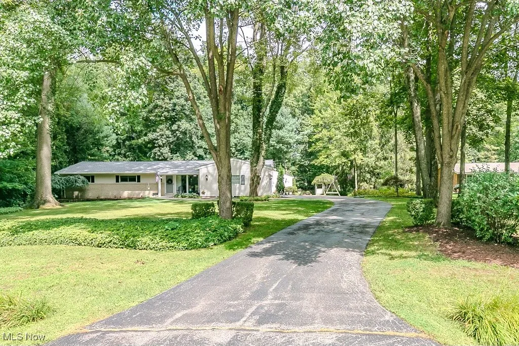 View of front of home featuring a front lawn, driveway, and a porch