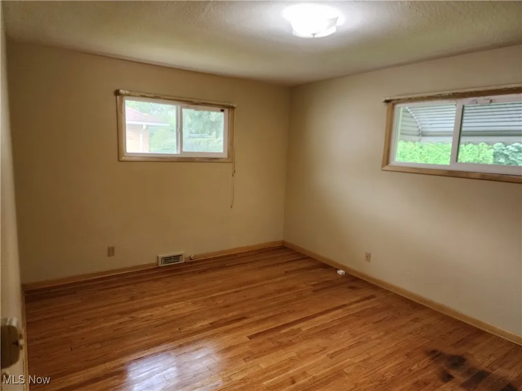 Unfurnished room featuring light wood finished floors and a textured ceiling