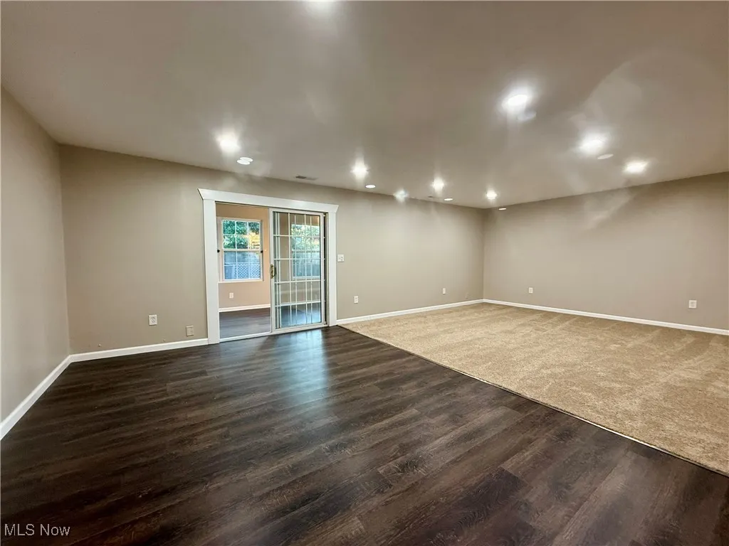 Empty room featuring dark wood finished floors and recessed lighting